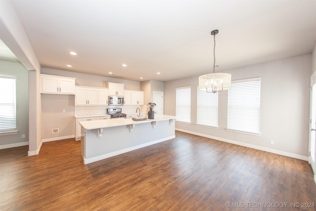 kitchen with a center island with sink, white cabinets, dark hardwood / wood-style floors, and appliances with stainless steel finishes