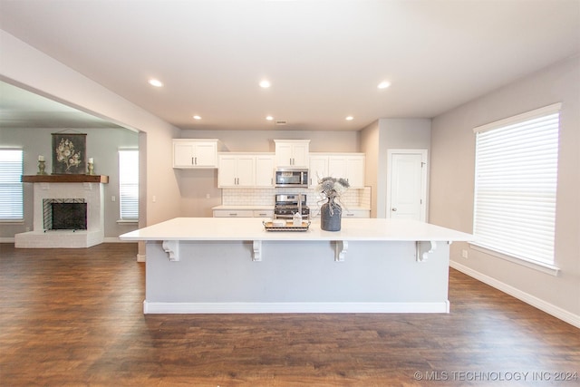 kitchen featuring a kitchen breakfast bar, stainless steel appliances, dark hardwood / wood-style floors, and a large island