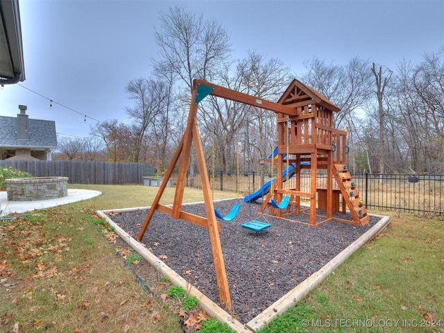 view of jungle gym featuring a fire pit and a lawn