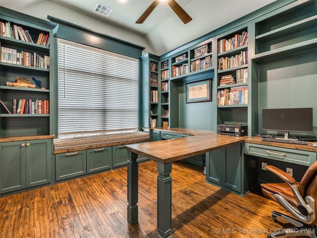 unfurnished office featuring built in desk, dark hardwood / wood-style flooring, ceiling fan, and lofted ceiling