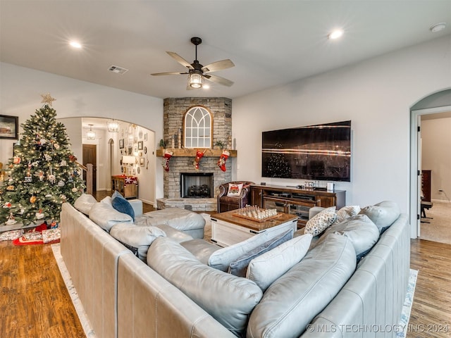 living room featuring a fireplace, light hardwood / wood-style flooring, and ceiling fan