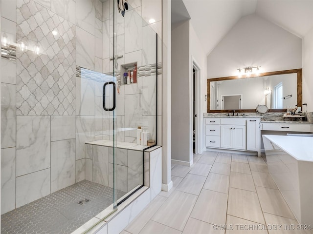 bathroom with tile patterned flooring, vanity, a shower with shower door, and vaulted ceiling