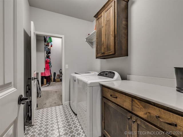 laundry room with washer and dryer, cabinets, and light tile patterned flooring