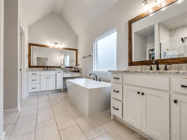 bathroom with tile patterned flooring, vanity, shower with separate bathtub, and vaulted ceiling