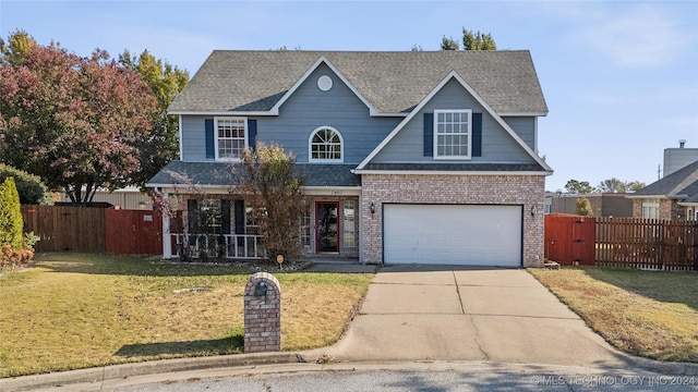 view of front of house featuring a porch, a garage, and a front lawn