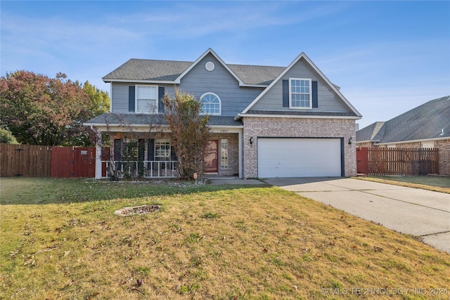 view of front of property featuring covered porch, a garage, and a front lawn