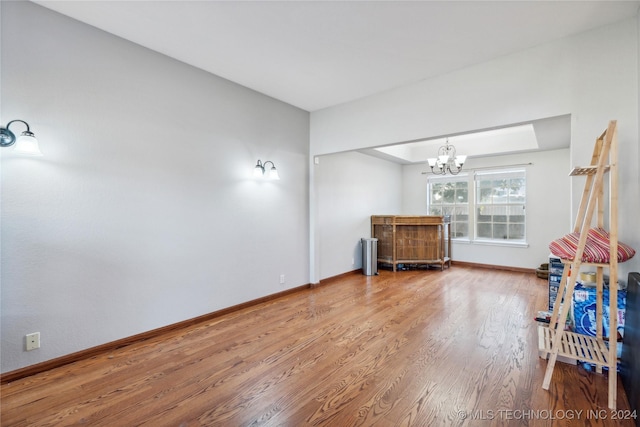 spare room featuring hardwood / wood-style floors and an inviting chandelier