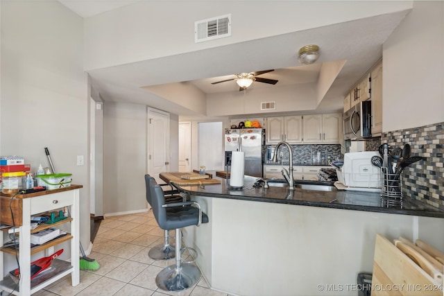 kitchen featuring decorative backsplash, kitchen peninsula, sink, and appliances with stainless steel finishes