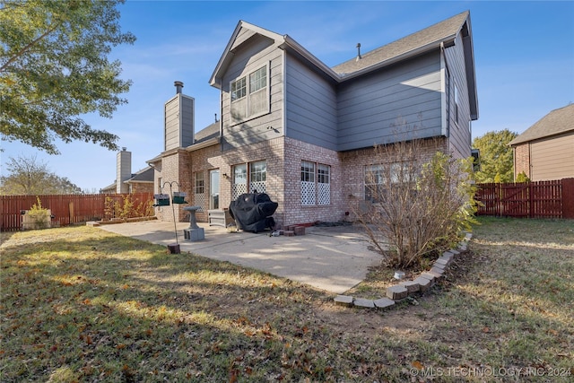 back of property featuring a lawn and a patio area