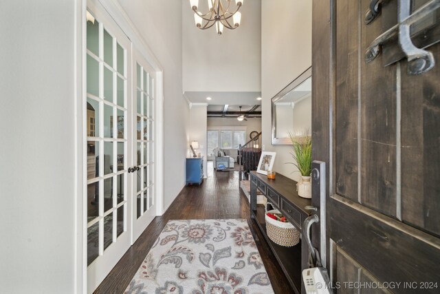 foyer featuring a chandelier, french doors, dark hardwood / wood-style flooring, and a towering ceiling