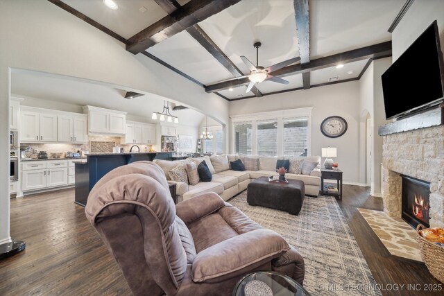 living room with coffered ceiling, a stone fireplace, dark hardwood / wood-style floors, and beamed ceiling