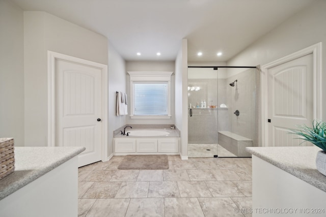 bathroom featuring vanity and independent shower and bath