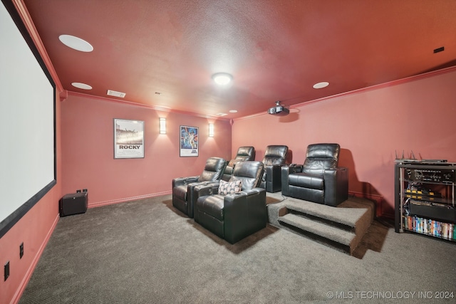 carpeted home theater featuring ornamental molding and a textured ceiling