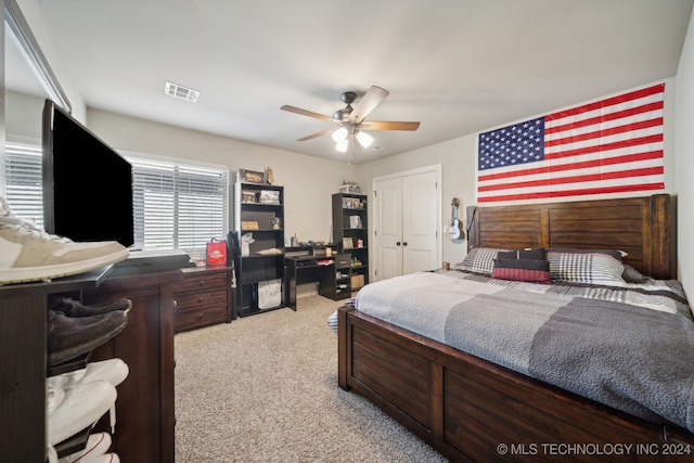 carpeted bedroom featuring ceiling fan and a closet