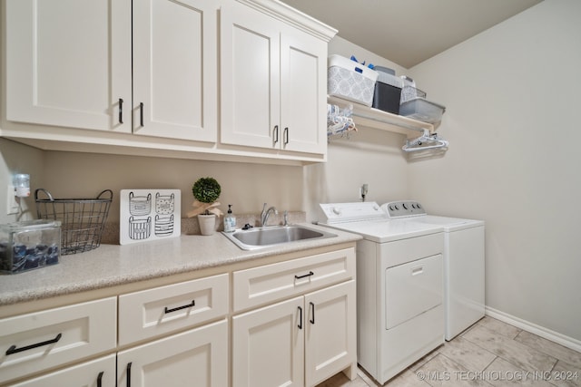 laundry area featuring sink, cabinets, and independent washer and dryer