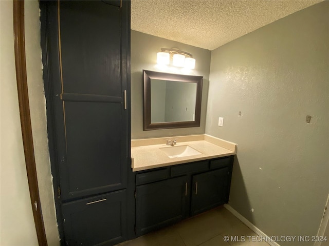 bathroom with vanity, a textured ceiling, and tile patterned floors