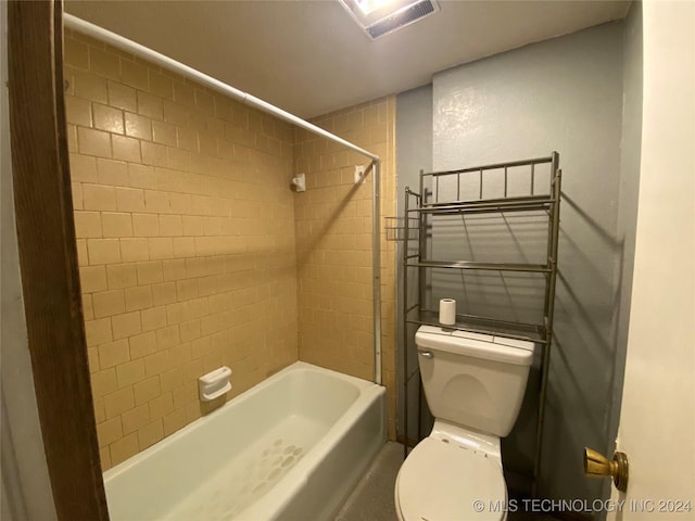 bathroom featuring tiled shower / bath combo and toilet