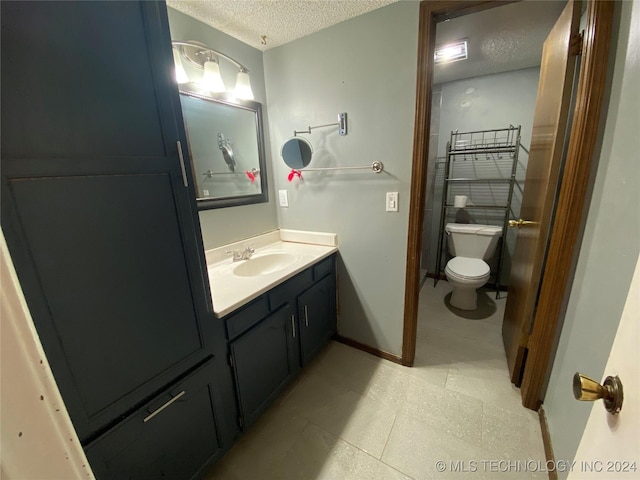 bathroom with vanity, a textured ceiling, and toilet