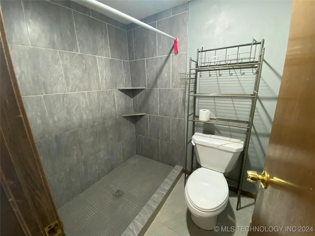 bathroom with toilet and a tile shower