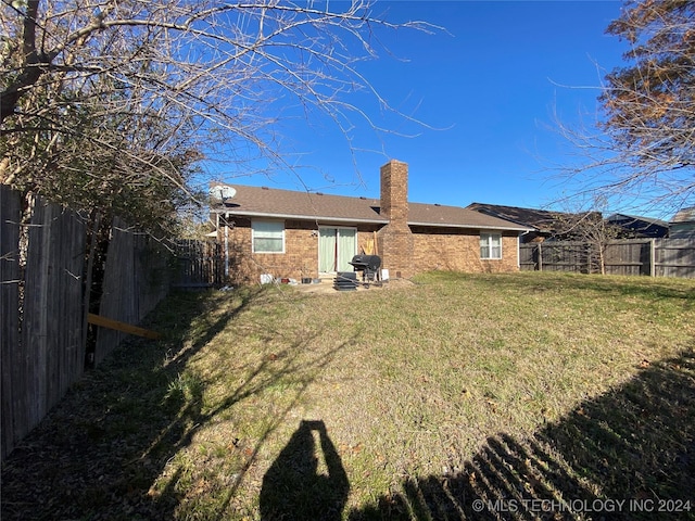 rear view of property with a lawn