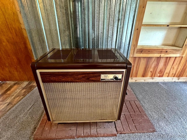 details with heating unit, wooden walls, and hardwood / wood-style floors