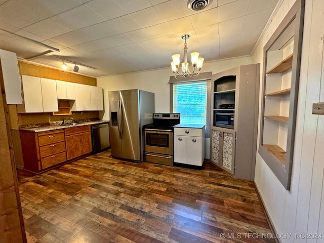 kitchen with appliances with stainless steel finishes, pendant lighting, white cabinetry, and dark wood-type flooring