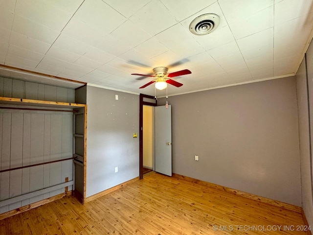 unfurnished bedroom with a closet, ceiling fan, light hardwood / wood-style flooring, and crown molding