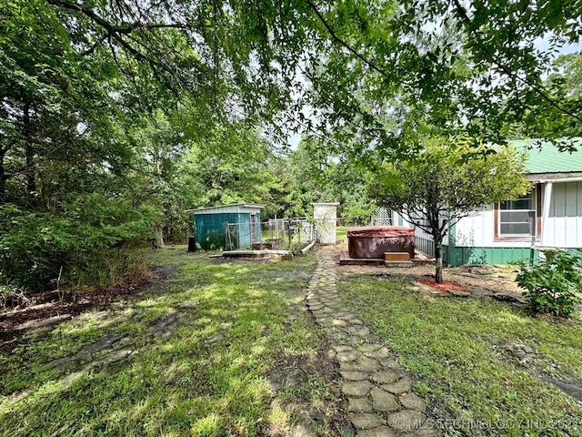 view of yard featuring a storage unit and a hot tub