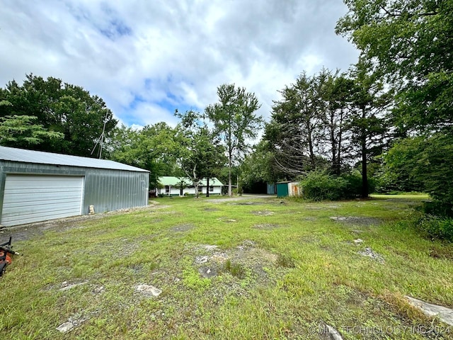 view of yard featuring an outdoor structure and a garage