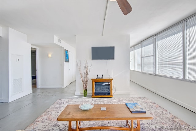 living room with ceiling fan and a fireplace