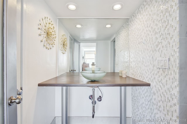 bathroom with vanity and tile walls