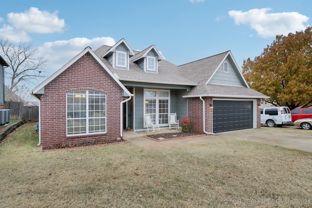 view of front of house with central AC, a garage, and a front lawn