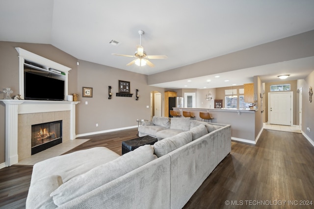 living room featuring hardwood / wood-style floors, ceiling fan, and a tile fireplace