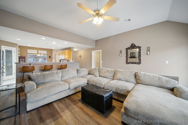 living room with hardwood / wood-style floors, vaulted ceiling, and ceiling fan