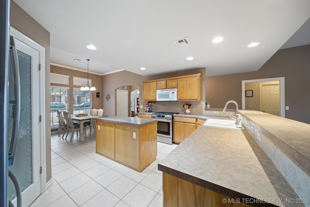 kitchen featuring an inviting chandelier, stainless steel range with gas cooktop, sink, ornamental molding, and kitchen peninsula