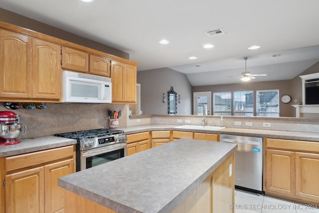 kitchen with a center island, backsplash, sink, ceiling fan, and stainless steel appliances