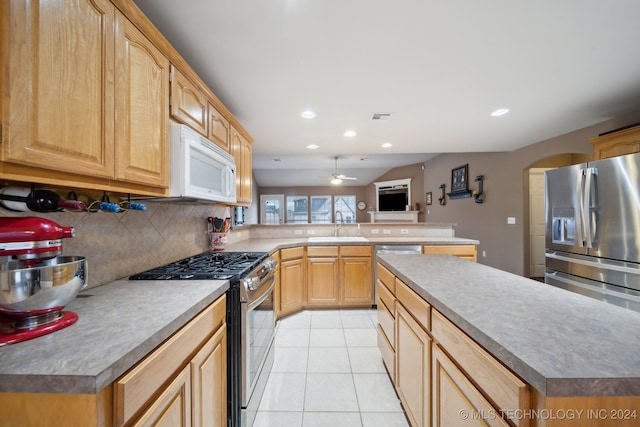 kitchen featuring ceiling fan, light brown cabinets, stainless steel appliances, backsplash, and light tile patterned floors