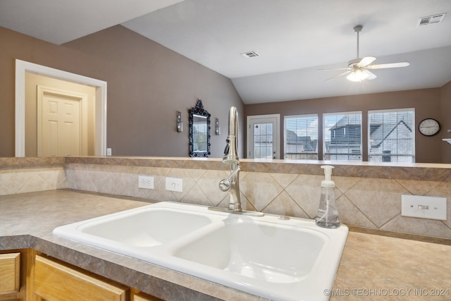 bathroom featuring ceiling fan, sink, and vaulted ceiling