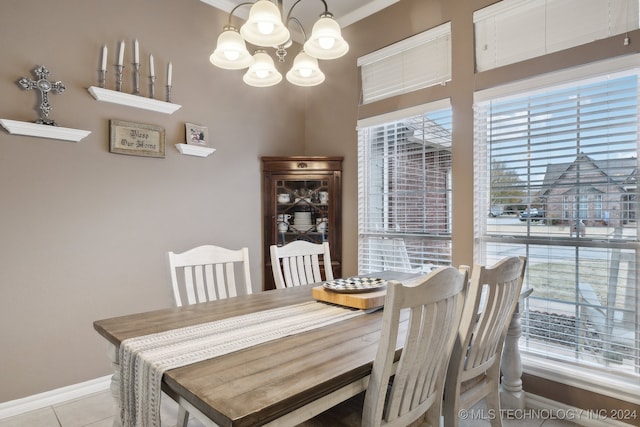 dining space featuring light tile patterned floors, a chandelier, and ornamental molding