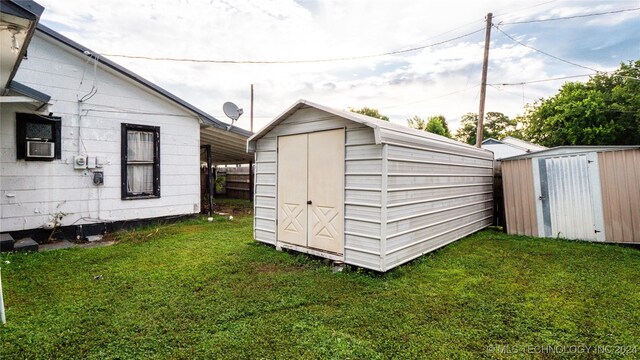 view of outdoor structure featuring cooling unit and a yard