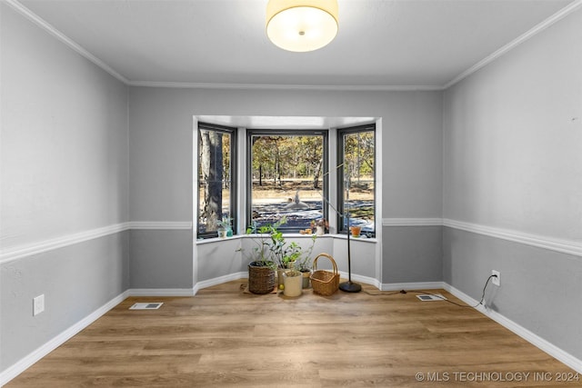 unfurnished room with crown molding and wood-type flooring