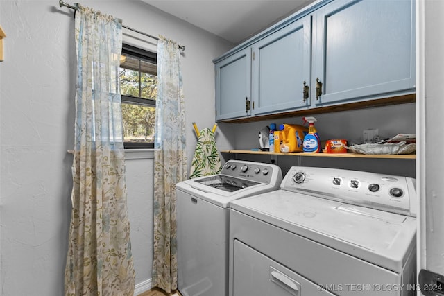 laundry area featuring washer and dryer and cabinets