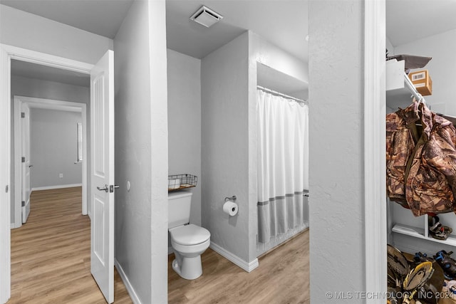 bathroom featuring wood-type flooring and toilet