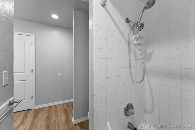 bathroom with wood-type flooring and tiled shower / bath combo