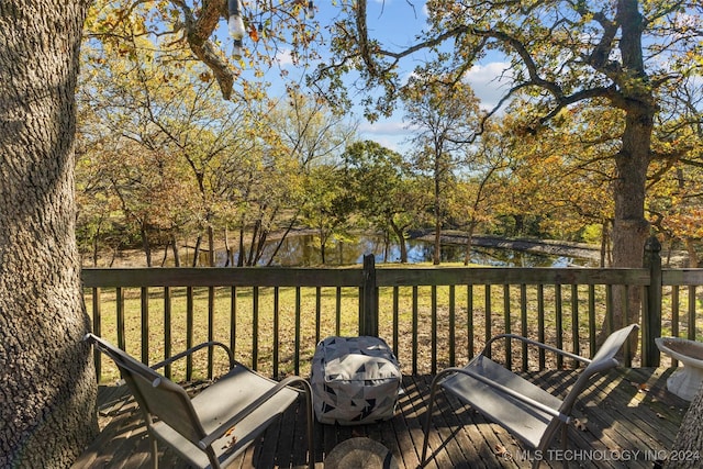 wooden deck featuring a lawn and a water view