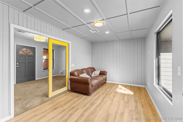 sitting room featuring wooden walls and light hardwood / wood-style floors