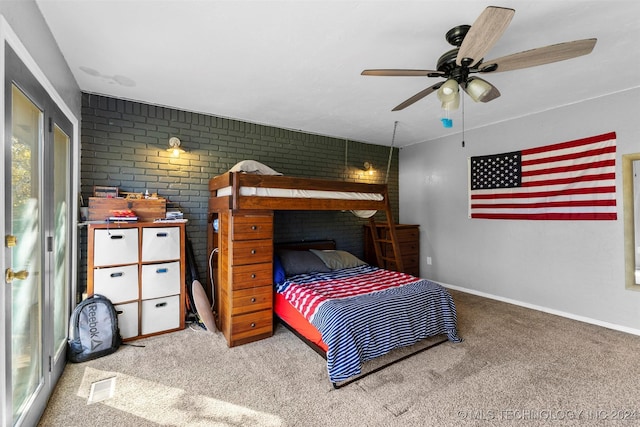 carpeted bedroom featuring ceiling fan and brick wall