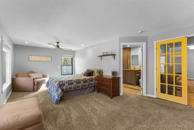 bedroom with ensuite bathroom, ceiling fan, and light carpet