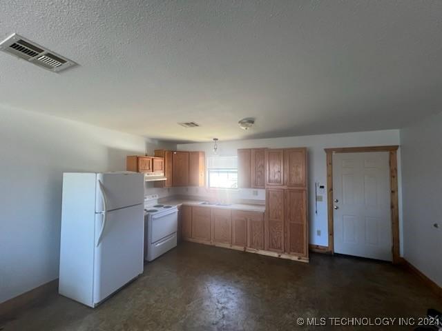 kitchen featuring a textured ceiling and white appliances