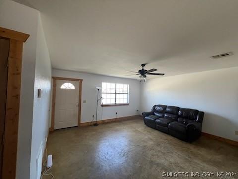 unfurnished living room featuring ceiling fan and concrete floors